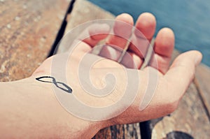 Young man with an infinity symbol tattooed in his wrist