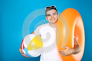Young man with inflatable ball and ring