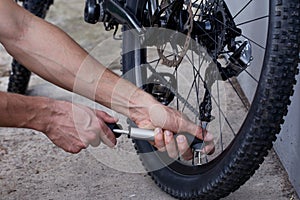 The young man inflates bicycle wheel