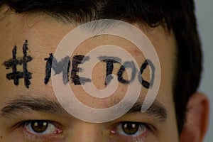 Young man with inscription `me too` ON FOREHEAD.