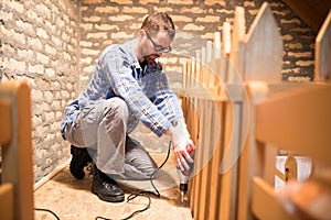 Young man installing chipboard flooring in the attic