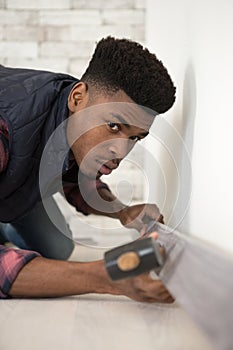 young man installing flooring