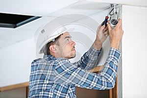 Young man installing interior security camera