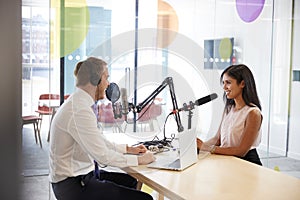 Young man interviewing a woman in a radio studio