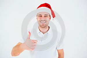 Young man isolated over white background. Guy in festive christmas red hat show big thumb up and smile. Cheerful