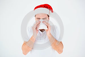 Young man isolated over white background. Guy in red christmas hat celebrate festive new year. Sick ill person sneezing