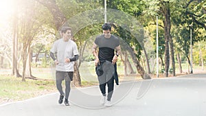 Young man jogging with friend in the park