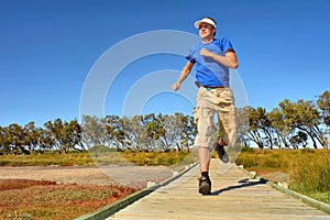 Young man jogs on woodwalk