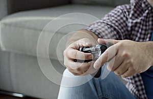 A young man with joystick playing video games at home spending t