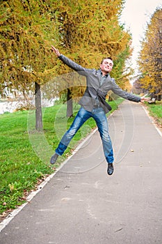 Young man jumping in autumn park