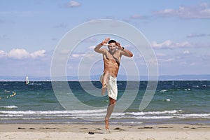 Young man jumping on the blue beach.
