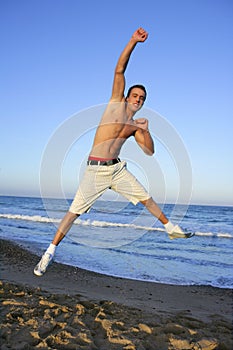 Young man jumping on the blue beach