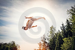 Young man jumping high in the sky.