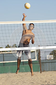 Young man jumping, hitting volleyball