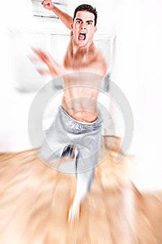 Young man jumping with kicking and clenched fists