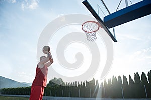 Young man jumping and making a fantastic slam dunk playing stree