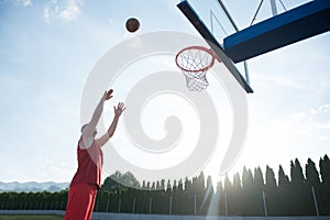 Young man jumping and making a fantastic slam dunk playing stree