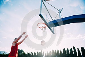 Young man jumping and making a fantastic slam dunk playing stree