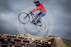 Young man jumping over hole in dirtjump circuit