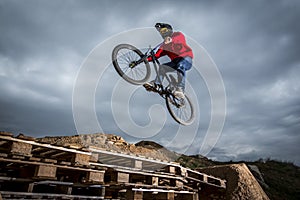 Young man jumping over hole in dirtjump circuit