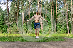 Young man jumping rope in a pine forest