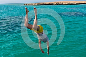 Young man is jumping into the sea