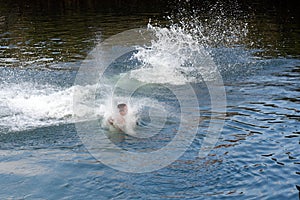 Young man jumps into the water splashing water