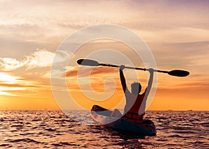 Giovane uomo kayak sul il mare sul tramonto 