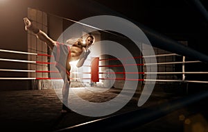 Young man kickboxing in the Arena