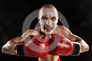 The young man kickboxing on black with kapa in mouth