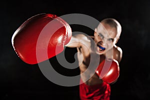 The young man kickboxing on black with kapa in mouth