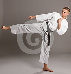 Young man in kimono kicks the leg.