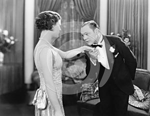 Young man kissing an elegant woman's hand