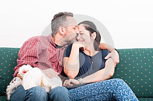 Young man kissing his wife on the couch