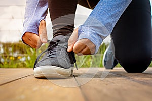 A young man lacing his shoe before a run early in the morning