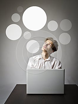 Young man with laptop. Man in white and gray bubbles