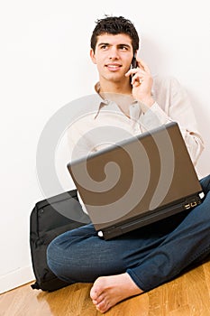 Young man on laptop and mobile