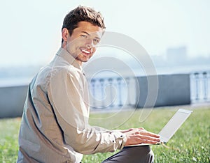 Young man with laptop outdoor portrtait