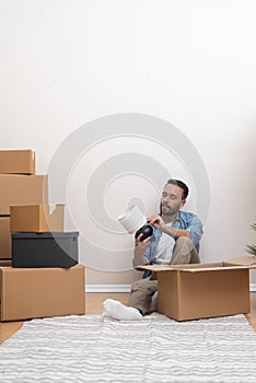 young man, laptop in use, embraces fresh start in new apartment amid the chaos of unpacked boxes