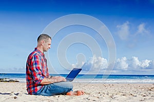 Young man with laptop working outdoor