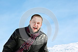 Young man laughs merrily in winter