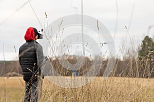 Young man launches rc plane into sky. Teenager with glasses playing with toy radio-controlled airplane outdoors. Boy