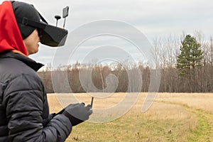 Young man launches rc plane into sky. Teenager with glasses playing with toy radio-controlled airplane outdoors. Boy