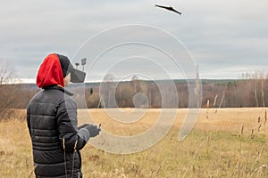 Young man launches rc plane into sky. Teenager with glasses playing with toy radio-controlled airplane outdoors. Boy