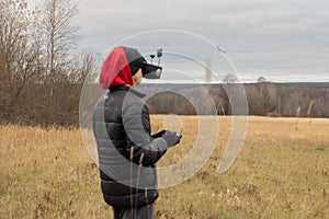 Young man launches rc plane into sky. Teenager with glasses playing with toy radio-controlled airplane outdoors. Boy