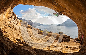 Young man lead climbing in cave