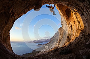 Young man lead climbing on ceiling in cave