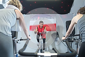 young man leading cycling fitness class