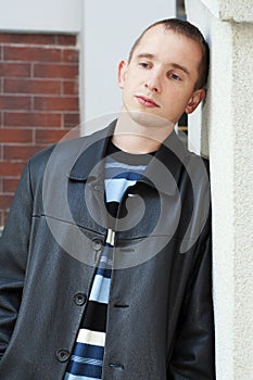 Young man leaning against wall photo