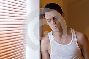 young man leaning against wall